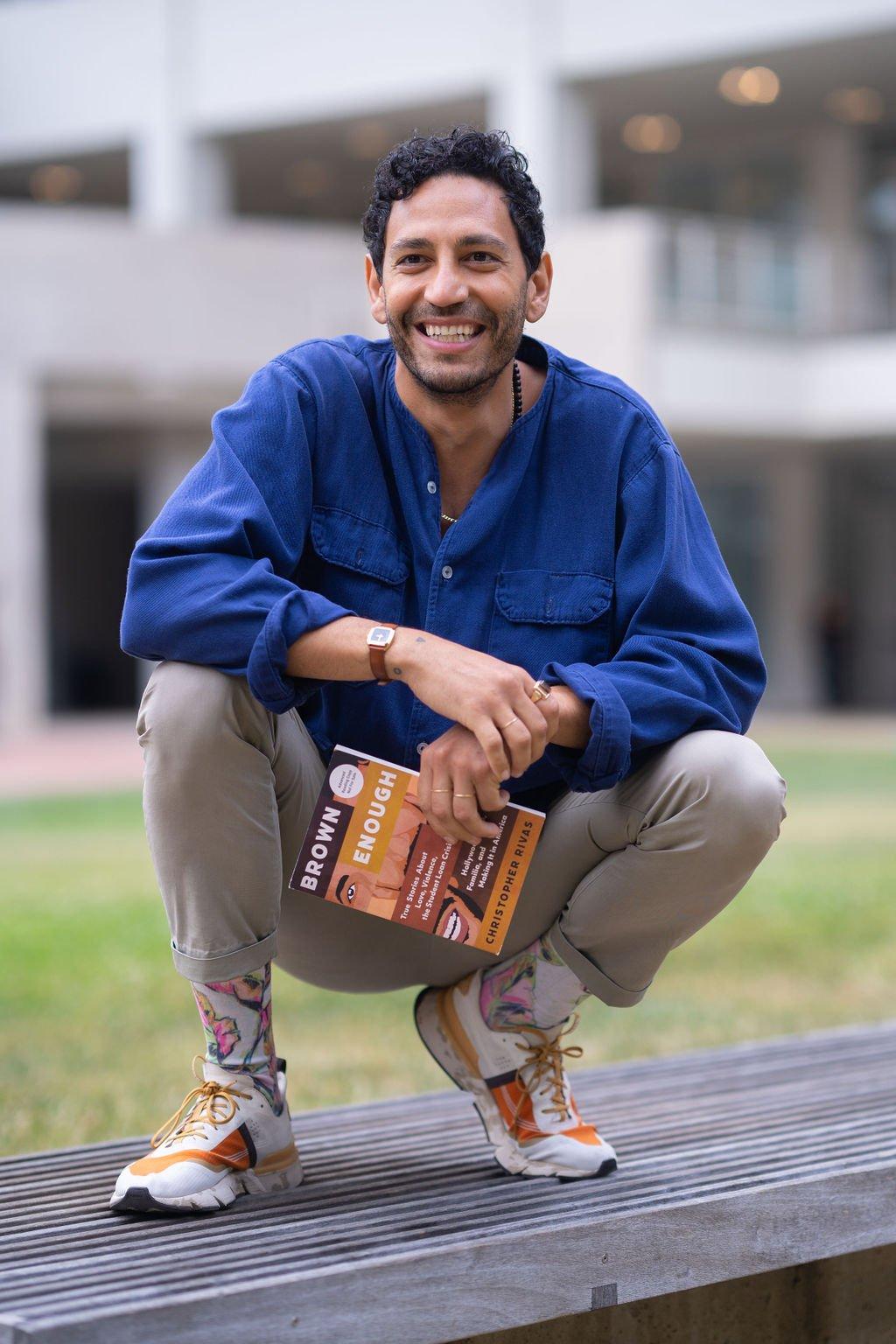 Christopher Rivas holding his book Brown Enough